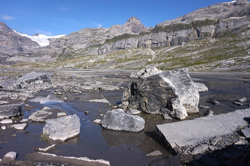 Stone-walled valley with a footpath leading toward distant peaks