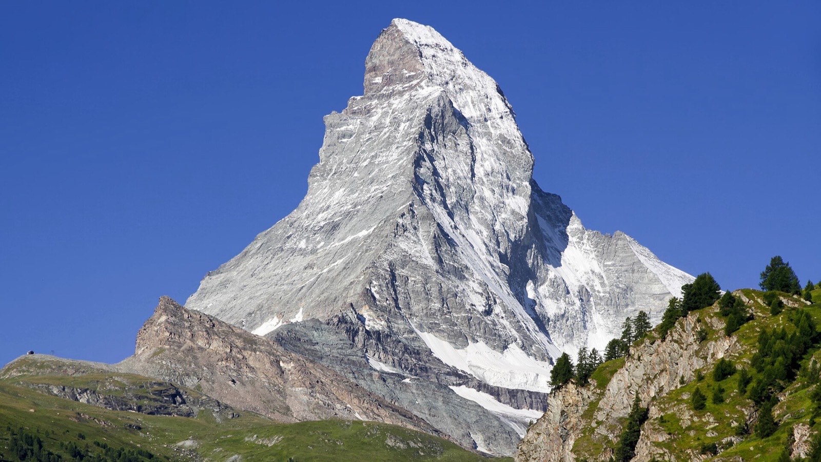 Granite alpine ridges fading into haze under a pale Swiss sky